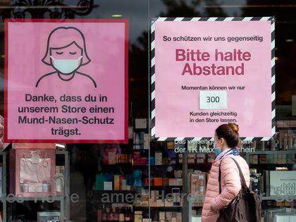 El escaparete de una tienda de Berl&#237;n informa de las recomendaciones sobre el uso de mascarilla, la distancia de seguridad y el aforo m&#225;ximo en el interior del establecimiento. EFE/EPA/HAYOUNG JEON
