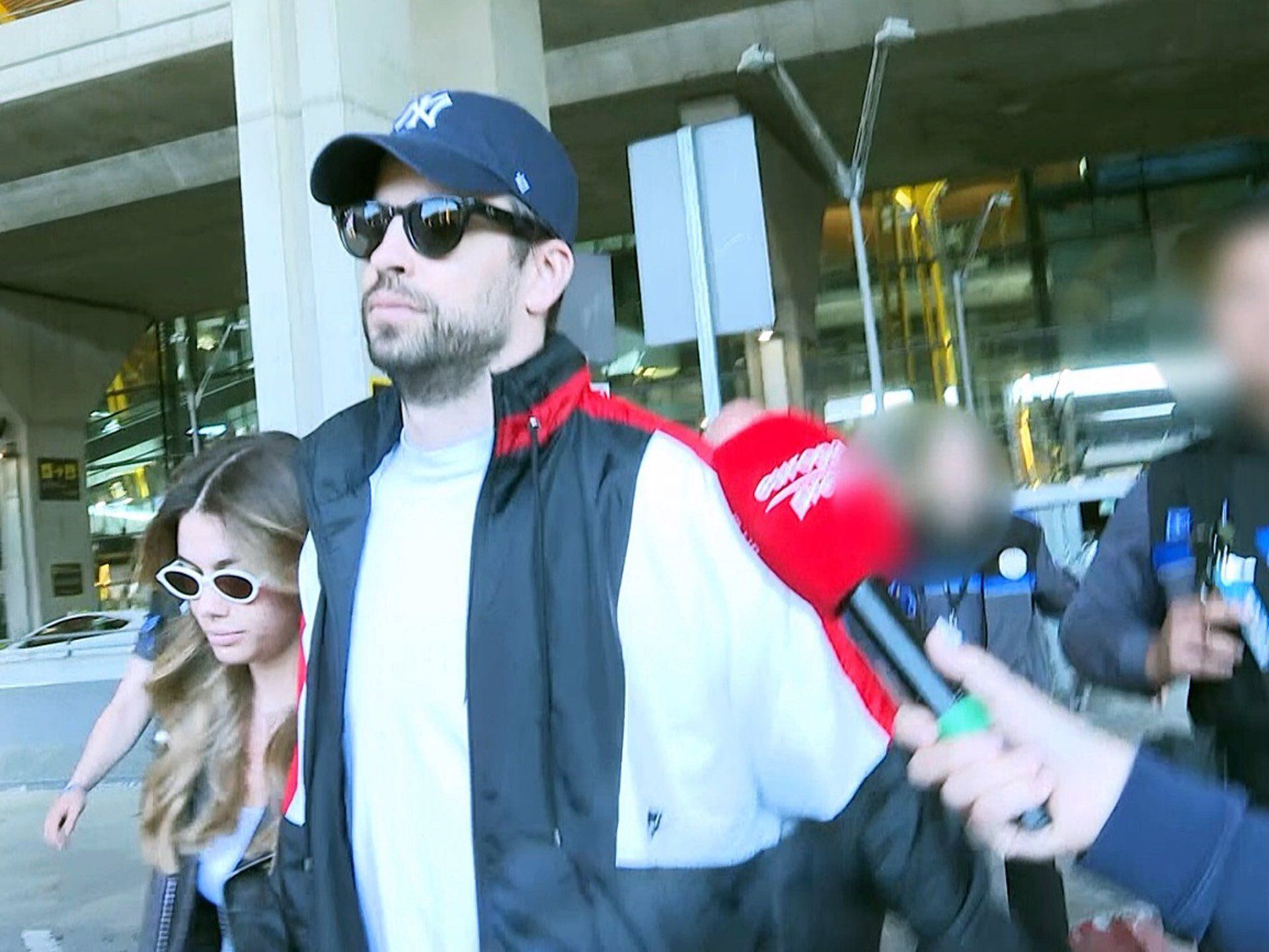 Gerard Piqué y Clara Chía se mostraron distantes de la prensa durante su paso por el aeropuerto de Madrid. La seguridad que les acompañaba tuvo un altercado con los reporteros gráficos en el lugar - crédito Europa Press