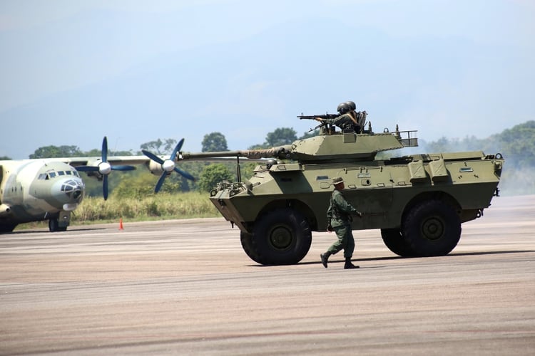 Un automóvil blindado Dragoon 300. Por detrás, un transporte de fabricación china Shaanxi Y-8 (Reuters)