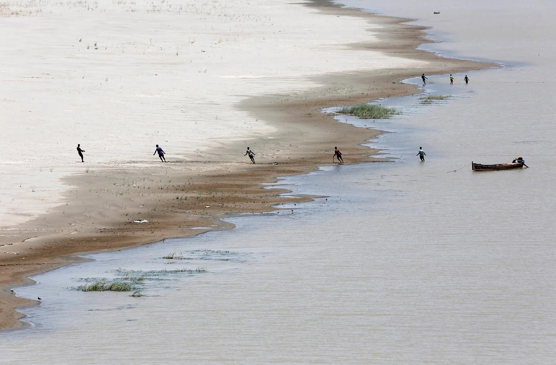 Pescadores tiran de una red en el río Indus, en Hyderabad, Pakistán (Reuters)