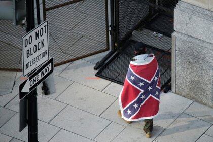 Un hombre envuelto con una bandera confederada camina cerca del perímetro antes de la toma de posesión del presidente electo de Estados Unidos, Joe Biden, en Washington, Estados Unidos, el 20 de enero de 2021. REUTERS / Eduardo Munoz