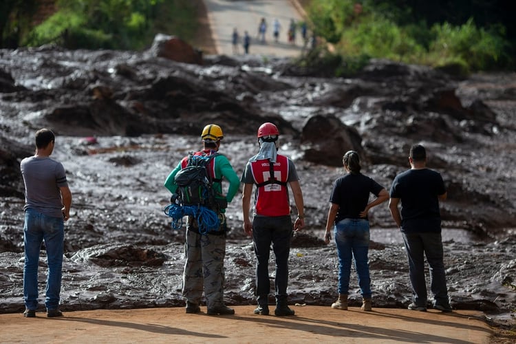 Rescatistas observan los residuos liberados por el colapso del dique en Minas Gerais (AFP)
