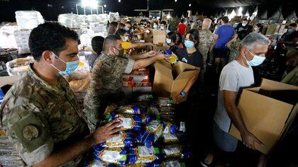 Lebanese army members and volunteers prepare aid to be distributed to people in the aftermath of a massive explosion in Beirut's port area, in Beirut, Lebanon August 12, 2020. REUTERS/Thaier Al-Sudani