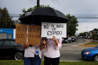 La gente sostiene carteles que dicen "El dictador de Bukele" y "No al golpe", mientras protestan contra la destitución de los jueces de la Corte Suprema y del Fiscal General por parte del Congreso salvadoreño, en San Salvador, El Salvador, el 2 de mayo de 2021.
REUTERS/ Jose Cabezas