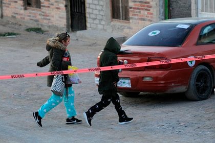 Personas caminan por la zona donde fue asesinado un hombre, el pasado 19 de febrero de 2021, en ciudad Juárez, en el estado de Chihuahua (Foto: EFE/Luis Torres)
