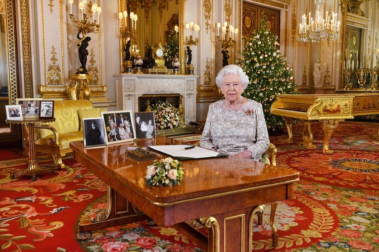 En el plano abierto de esta fotografía de 2018 pueden verse dos imágenes en la que están el príncipe Harry y su esposa Meghan Markle. Este año prefirió borrarlos de la escena (Shutterstock)