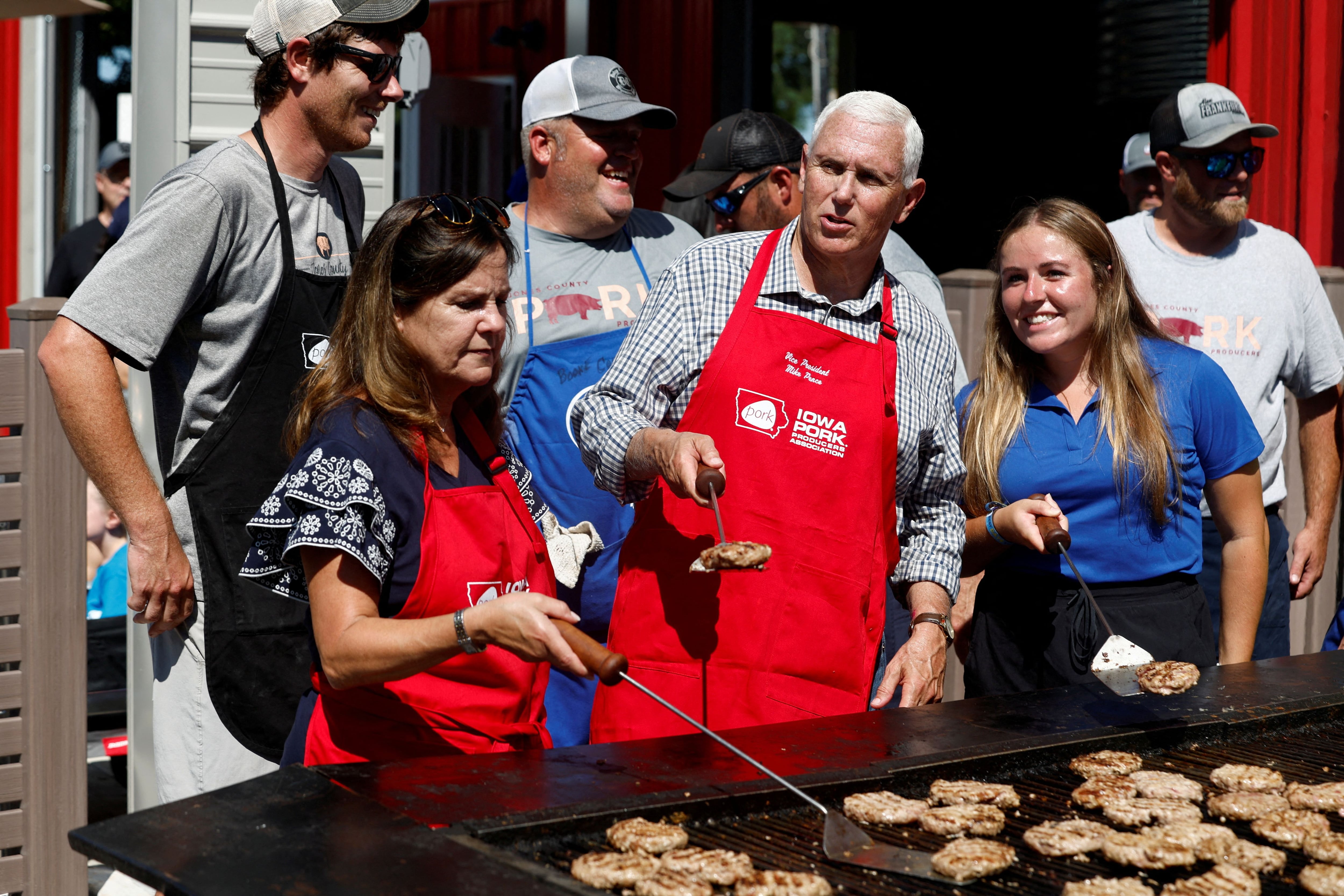 El ex vicepresidente, Mike Pence, haciendo hamburguesas en una feria rural de Des Moines, Iowa. (REUTERS/Evelyn Hockstein)      