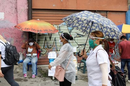 Médicos caminan por la calle entre vendedores, en medio de una jornada  mientras aumentan los casos por el brote por COVID-19, en Caracas, Venezuela Julio 14, 2020. Foto tomada el 14 de julio, 2020. REUTERS/Manaure Quintero