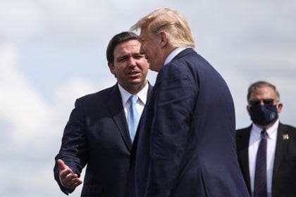 El presidente Donald Trump es recibido por el gobernador de Florida Ron DeSantis cuando llega al Aeropuerto Internacional del Suroeste de Florida, el 16 de octubre de 2020 (REUTERS/Carlos Barria)