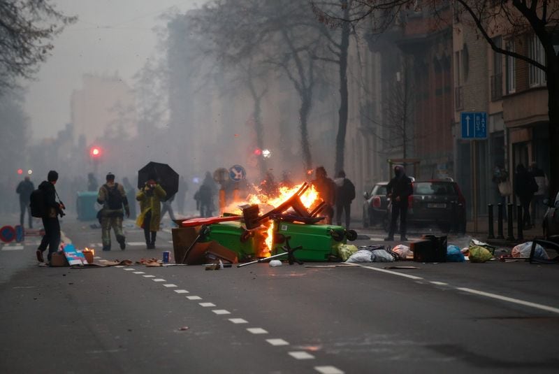 Objetos en llamas se ven en la calle durante una protesta contra las restricciones impuestas por el gobierno belga para contener la propagación de la enfermedad del coronavirus (COVID-19), en Bruselas, Bélgica, el 5 de diciembre de 2021. REUTERS/Johanna Geron