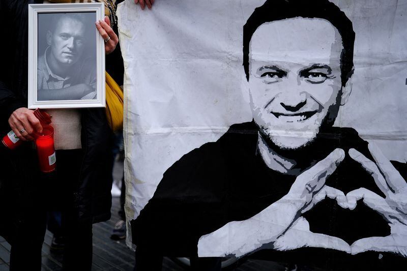 Una mujer sostiene velas y un retrato del fallecido líder de la oposición rusa Alexei Navalny (REUTERS/Nacho Doce)