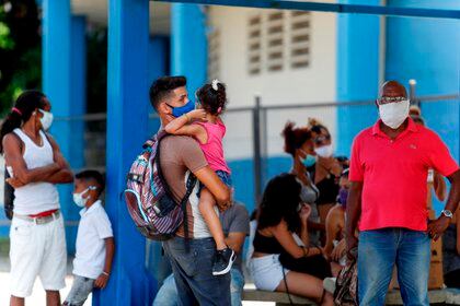 Varias personas esperan en una parada de ómnibus, en La Habana (EFE/Yander Zamora/Archivo)