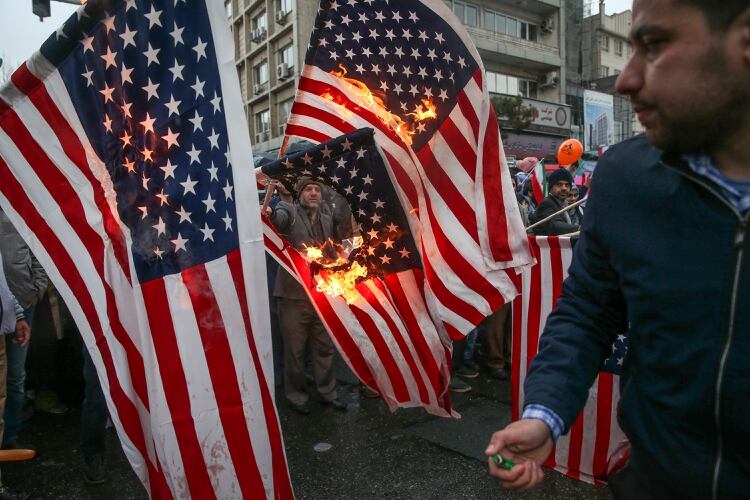 Ciudadanos iraníes queman banderas estadounidenses durante una ceremonia para conmemorar el 40 aniversario de la Revolución Islámica en Teherán, Irán, el 11 de febrero de 2019 (Meghdad Madadi/Agencia de Noticias Tasnim/via REUTERS)