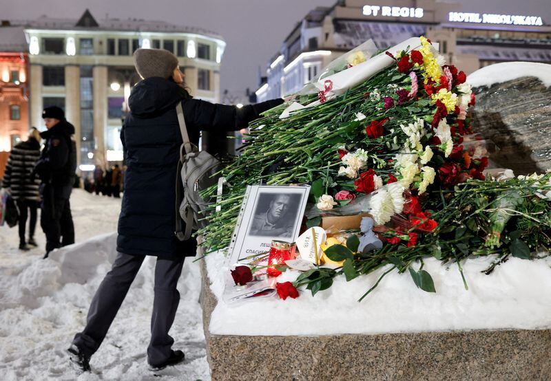 Una mujer deposita flores en el monumento a las víctimas de la represión política tras la muerte del líder opositor ruso Alexei Navalny, en Moscú, Rusia. 16 de febrero de 2024 (REUTERS/Stringer)