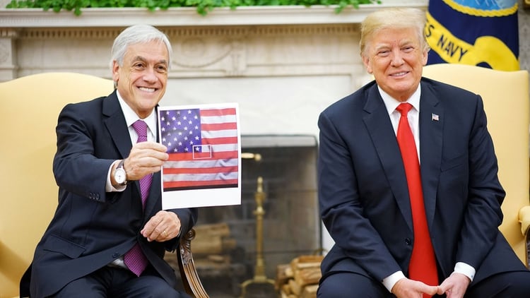 El presidente de Chile, Sebastián Piñera, sostiene una foto de la bandera chilena representada en el centro de la bandera de los Estados Unidos durante una reunión con el presidente de los Estados Unidos, Donald Trump, en la Oficina Oval de la Casa Blanca en Washington, EE.UU, el 28 de septiembre de 2018 (Reuters)
