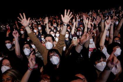 Personas con máscaras protectoras asisten a un concierto de "Love of Lesbian" en el Palau Sant Jordi, el primer concierto masivo desde el inicio de la pandemia