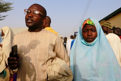 Un hombre camina con su hermana mientras se reúnen después de que ella llegara junto con otras colegialas rescatadas en Jangebe (REUTERS/Afolabi Sotunde)