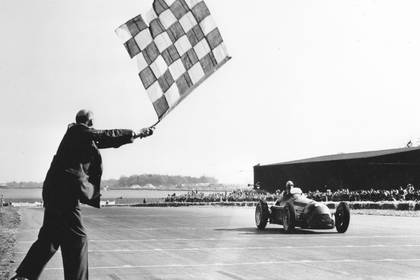 Giuseppe Farina recibe la bandera de cuadros y gana la primera carrera en la historia de la Fórmula 1.