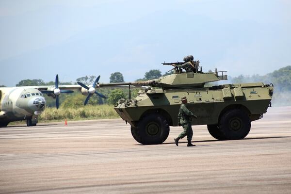 Un automóvil blindado Dragoon 300. Por detrás, un transporte de fabricación china Shaanxi Y-8 (Reuters)