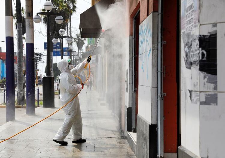 Un trabajador municipal limpia las calles y fachadas en el barrio de Chorrillos, en Lima, Perú. 21 de marzo de 2020. REUTERS/Sebastian Castañeda