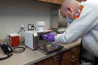 John Burke, jefe del Departamento de Bomberos de Sandwich, Massachusetts, con un dispositivo diseñado para detectar partículas de coronavirus en el aire (Foto: Thermo Fisher Scientific / New York Times)