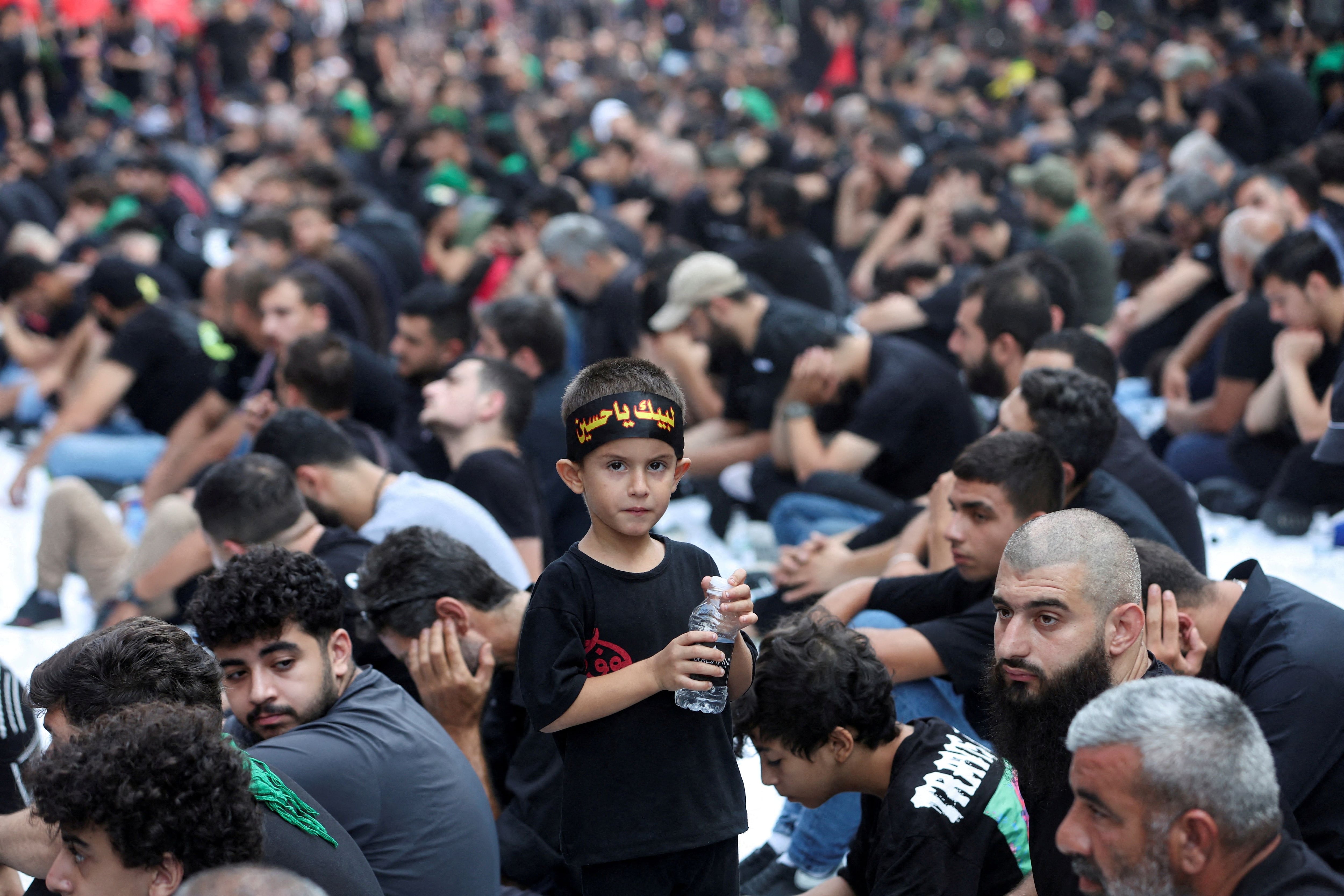 Un niño lleva una botella de agua mientras los partidarios de Hezbollah en Líbano participan en una ceremonia religiosa para conmemorar la Ashura en los suburbios del sur de Beirut, Líbano 29 de julio 2023. REUTERS/Aziz Taher 