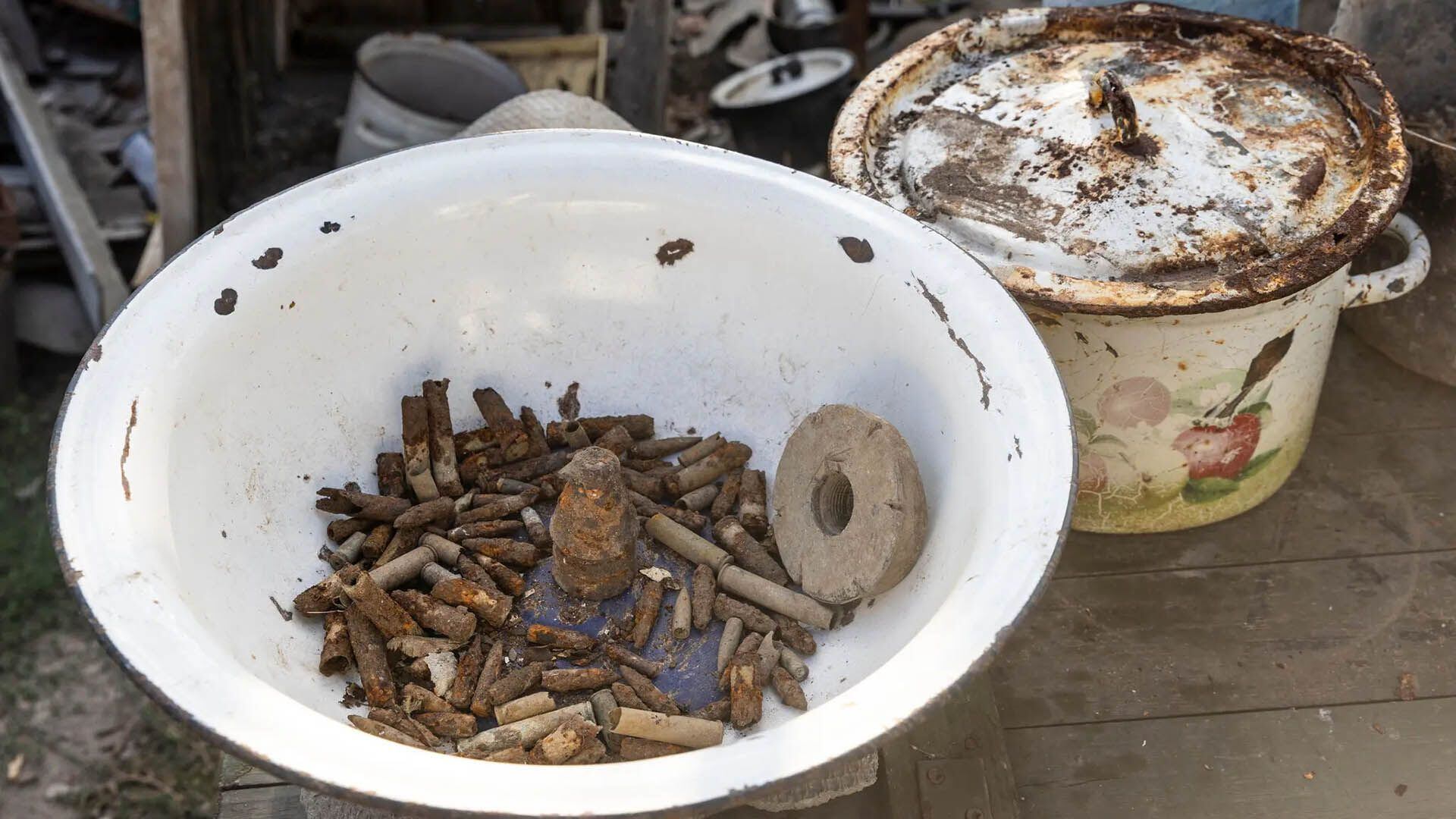 Se recogieron casquillos de bala de la Segunda Guerra Mundial en un recipiente en la casa de la Sra. Huk. Los residentes ven las dos guerras como parte de la misma violencia mortal (David Guttenfelder para The New York Times)