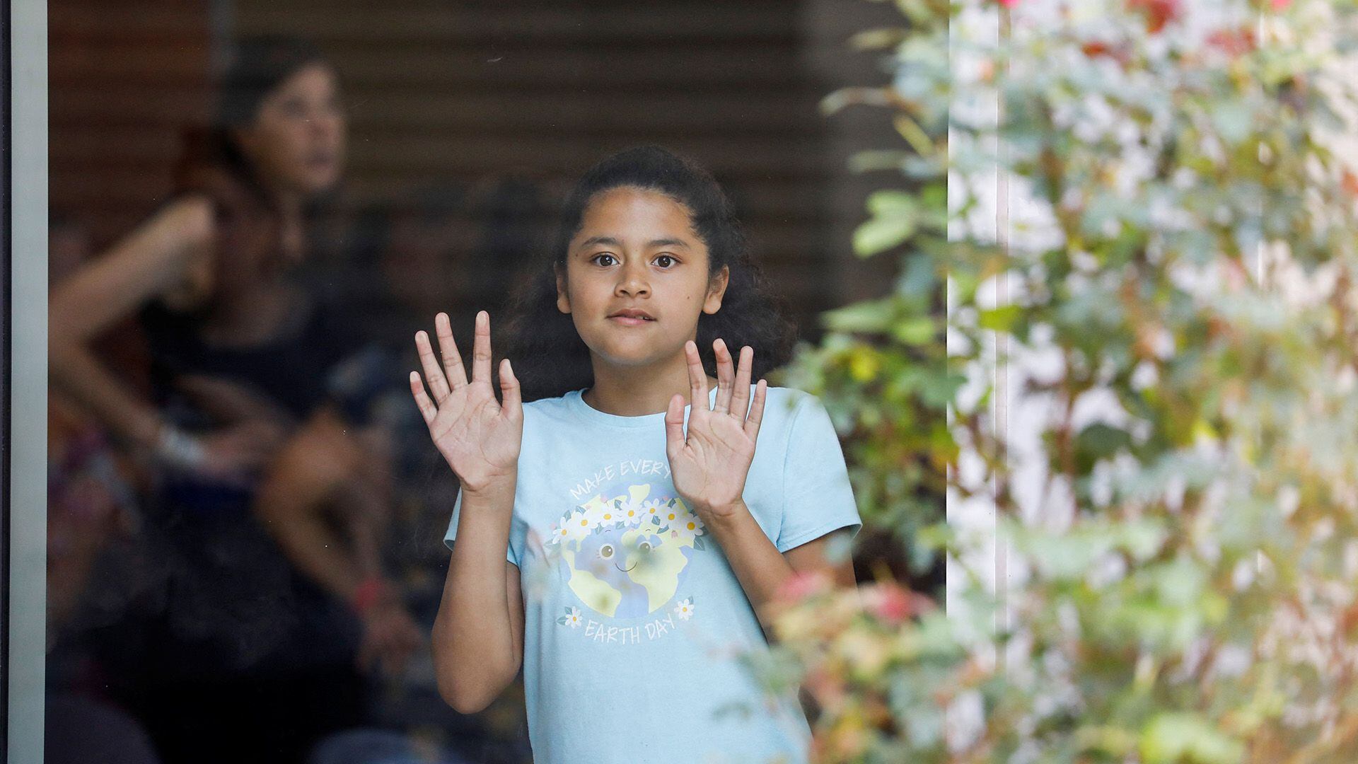 Una niña mira a través de una ventana de vidrio desde el interior del Centro Cívico Ssgt Willie de Leon (REUTERS/Marco Bello)