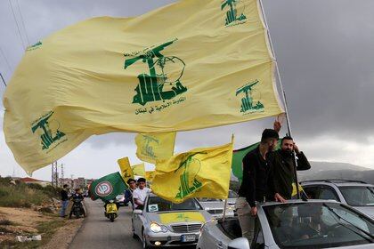 FILE PHOTO: A supporter of Lebanon's Hezbollah gestures as he holds a Hezbollah flag in Marjayoun, Lebanon May 7, 2018. REUTERS/Aziz Taher//File Photo