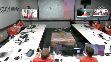 El equipo del Laboratorio de Propulsión a Chorro de la NASA (JPL, por sus siglas en inglés) reacciona después del primer vuelo del helicóptero de Marte Ingenuity en el planeta en esta imagen fija tomada de un video el 19 de abril de 2021 (NASA)