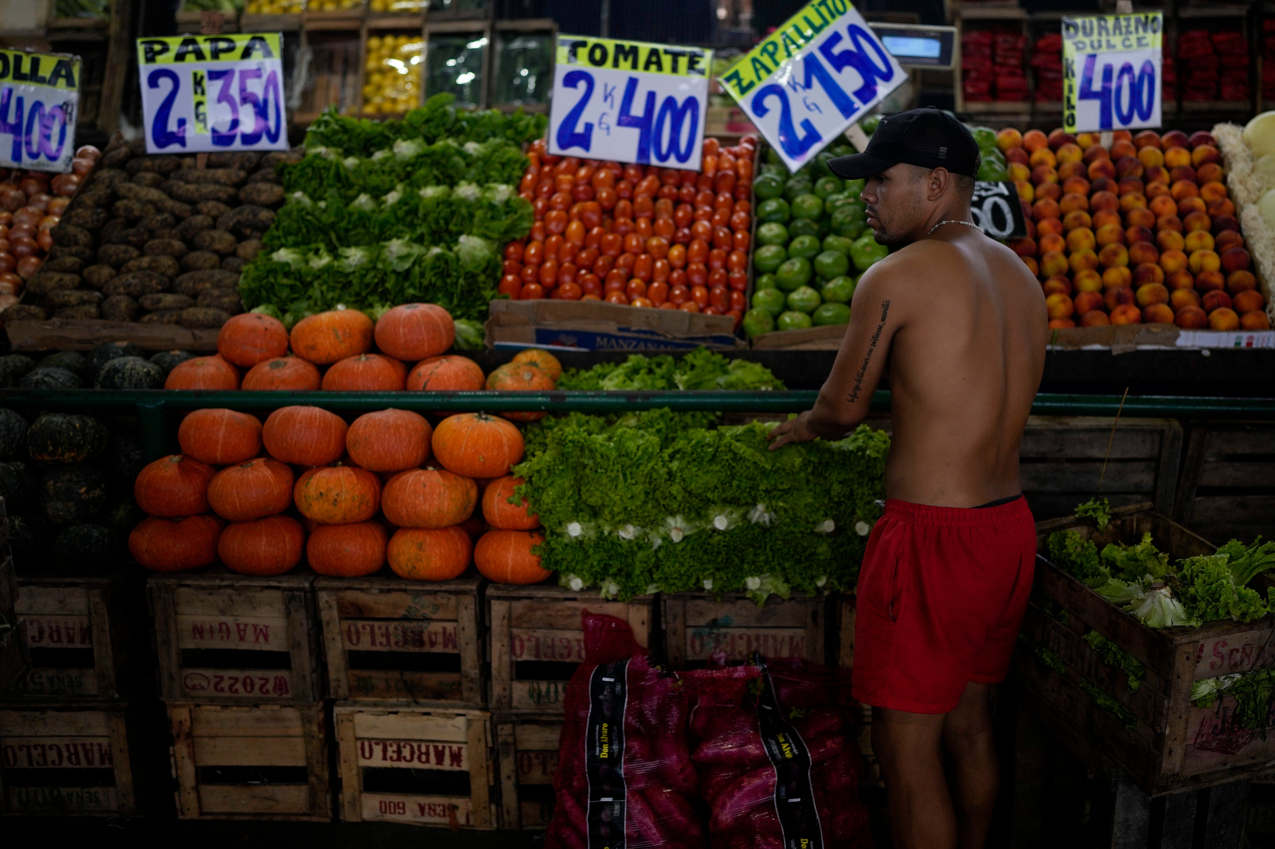 Un trabajador coloca sus productos frescos en el Mercado Central (AP Foto/Natacha Pisarenko)