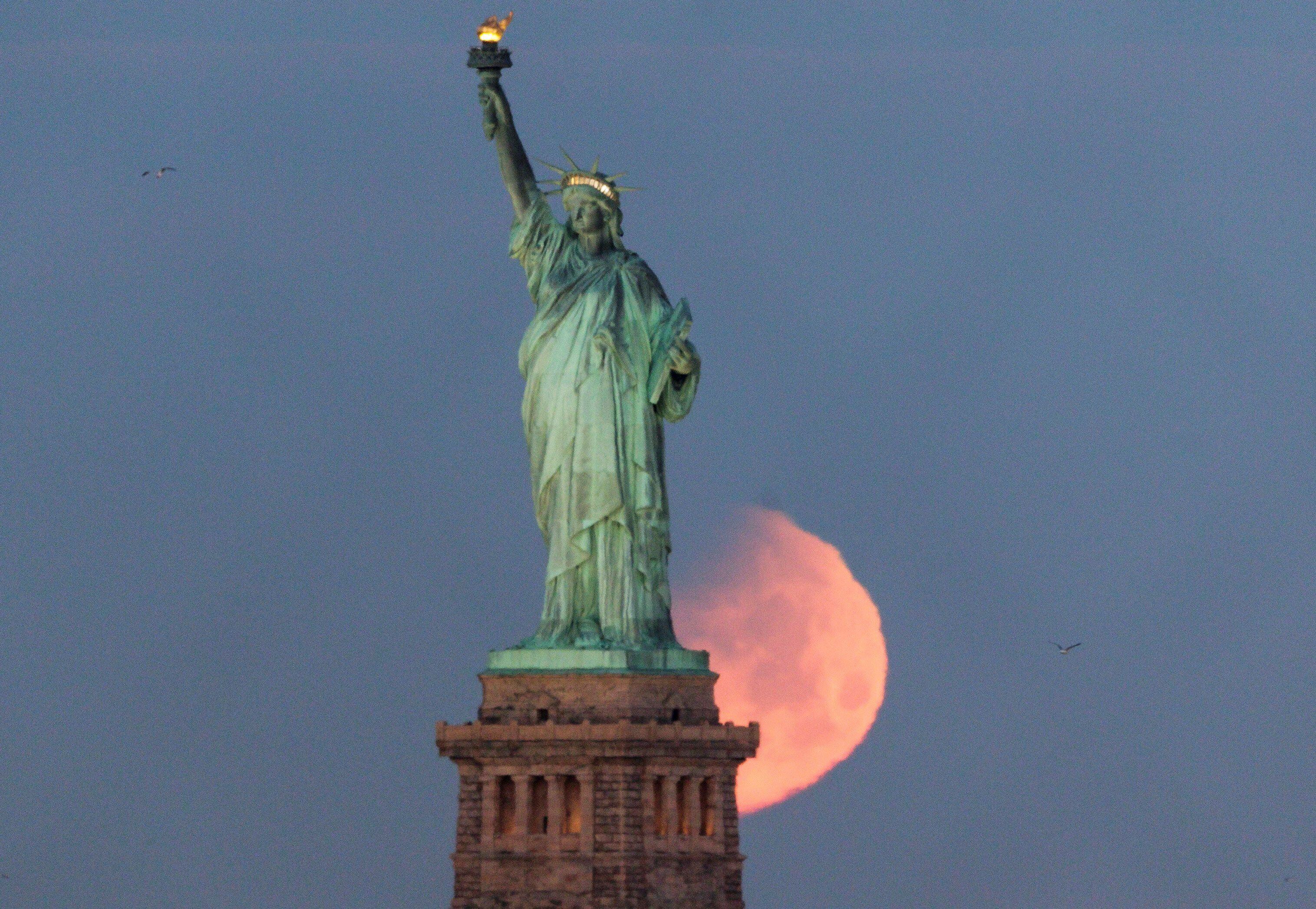 Vista de la luna tras la Estatua de la Libertad en Nueva York (Estados Unidos). EFE/ Justin Lane/Archivo