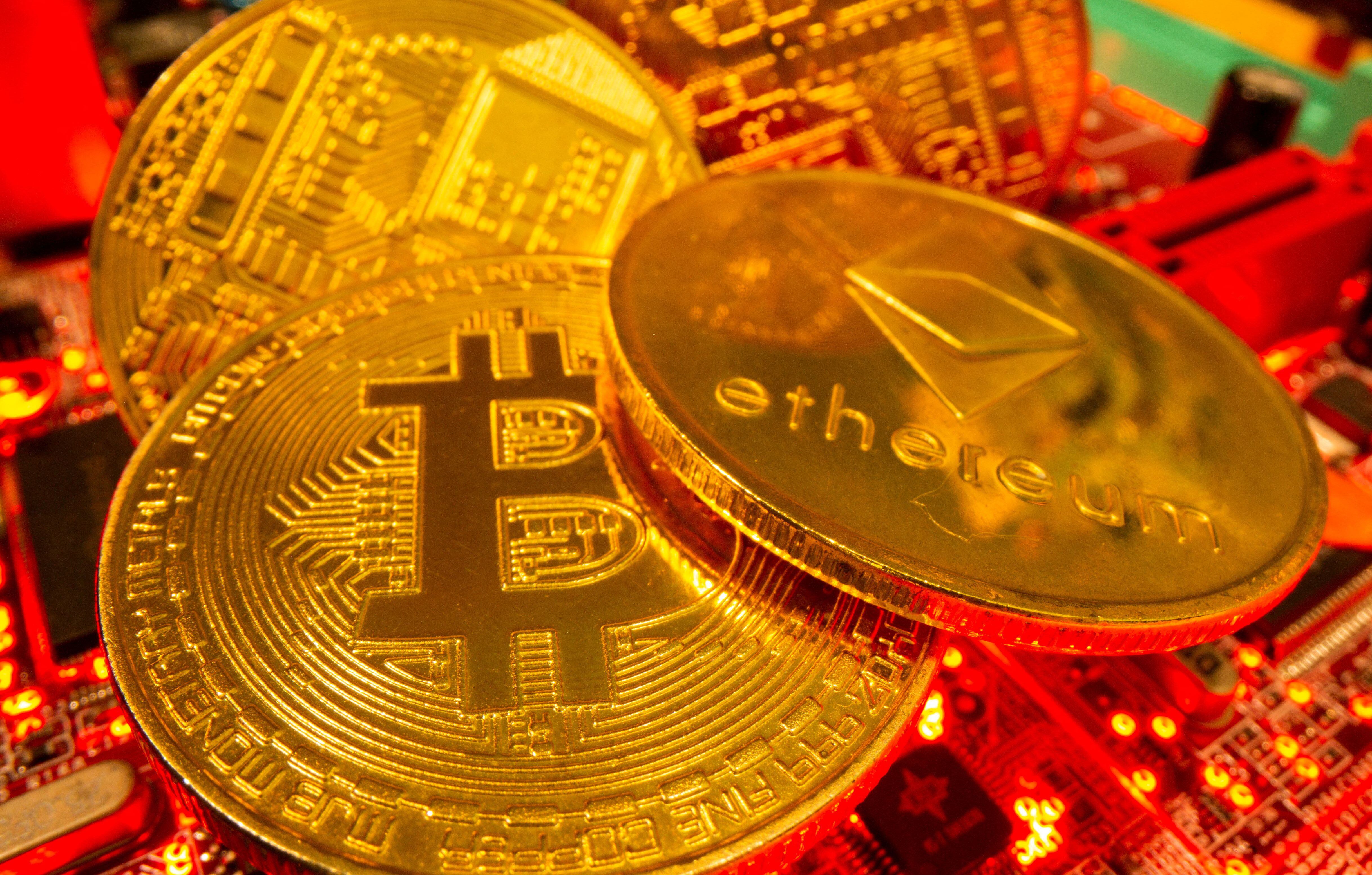 FILE PHOTO: Representations of the virtual currency Bitcoin and Ethereum stand on a motherboard in this picture illustration taken May 20, 2021. REUTERS/Dado Ruvic/Illustration/File Photo