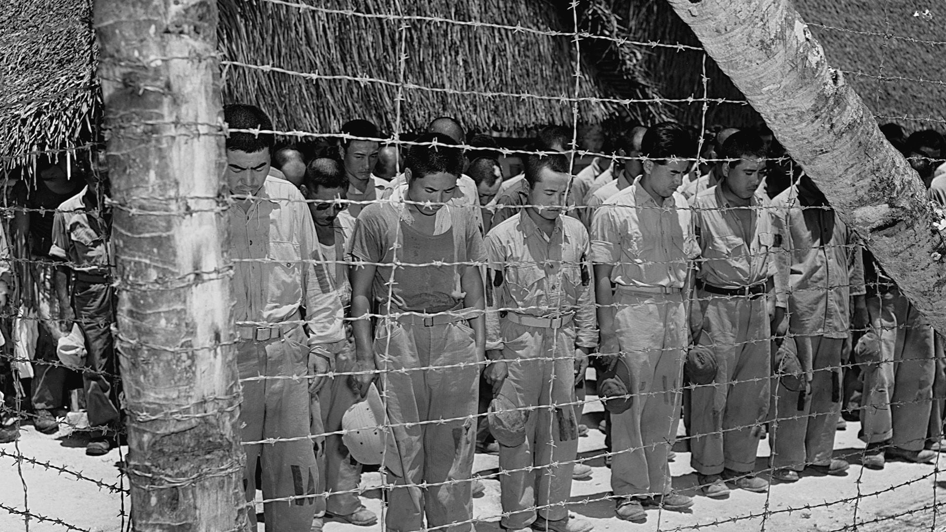 Prisioneros de guerra japoneses en Guam agachan su cabeza luego de escuchar el mensaje del emperador Hiroito que anunció la rendición incondicional de su país (Photo by © CORBIS/Corbis via Getty Images)
