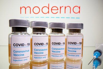 FILE PHOTO: Vials with a sticker reading, "COVID-19 / Coronavirus vaccine / Injection only" and a medical syringe are seen in front of a displayed Moderna logo in this illustration taken October 31, 2020. REUTERS/Dado Ruvic/File Photo