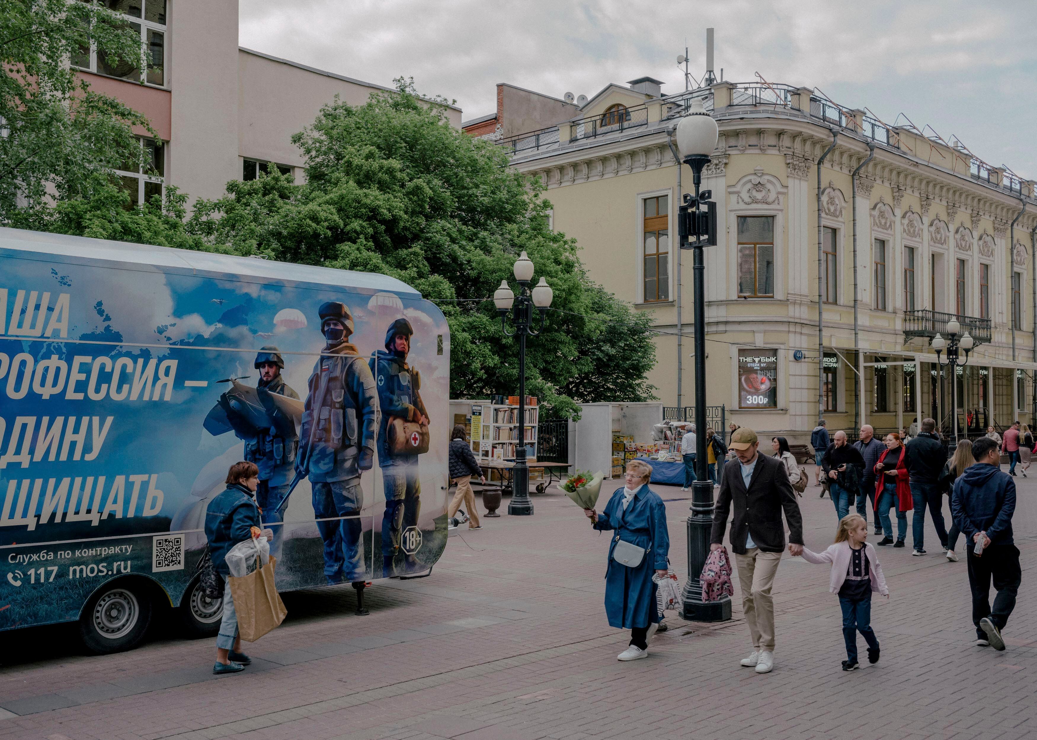 Varios peatones pasan junto a un autobús militar de reclutamiento en el centro de Moscú (Nanna Heitmann/The New York Times)