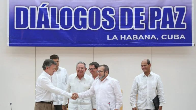 Juan Manuel Santos saluda al guerrillero “Timochenko” ante la mirada de Raúl Castro (Reuters)