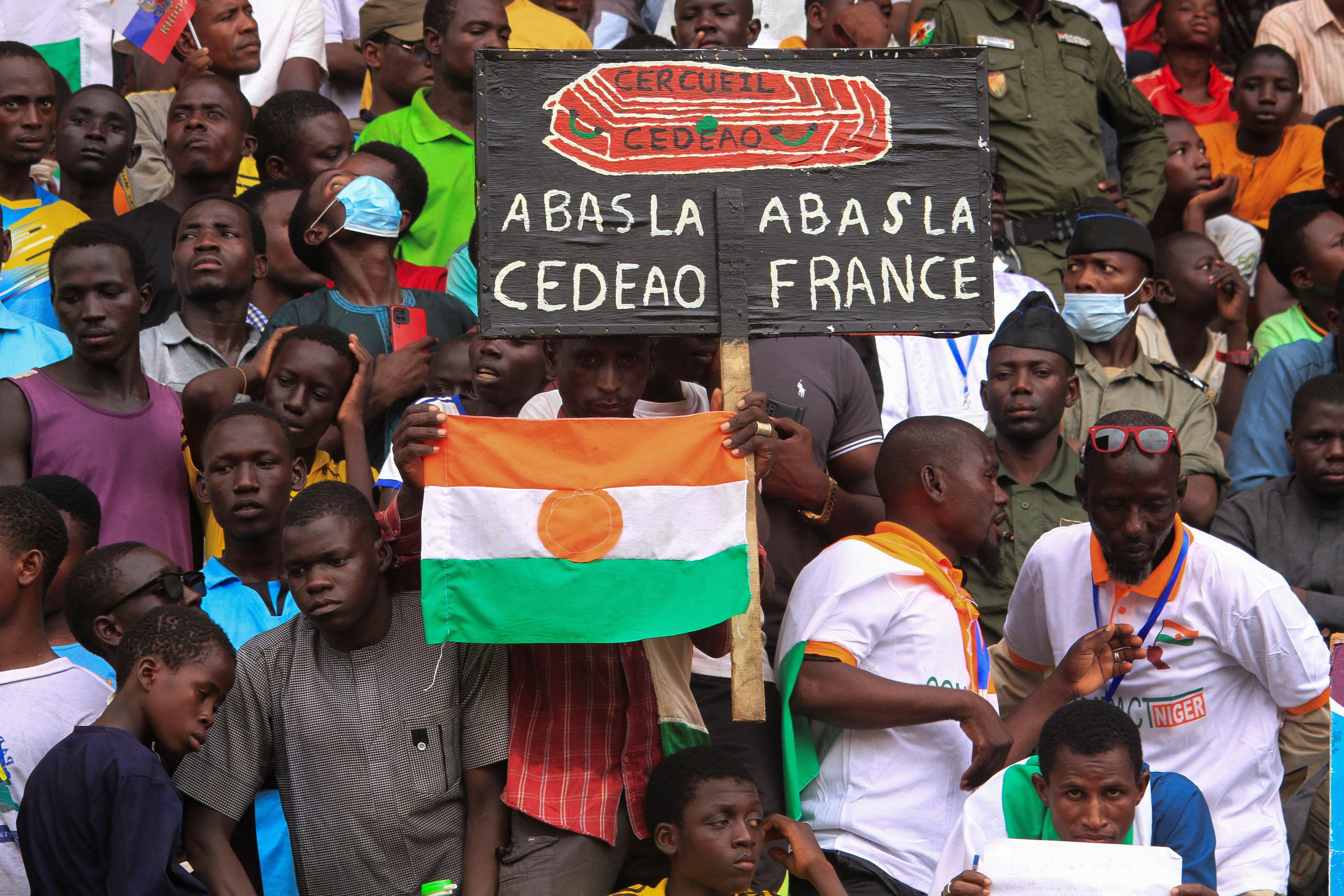 Nigerinos se reúnen un mes después del golpe, en apoyo a los soldados golpistas y para exigir la salida del embajador francés, en la capital Niamey este 26 de agosto de 2023. El cartel señala "Abajo la CEDEAO, abajo Francia" (REUTERS/Mahamadou Hamidou)