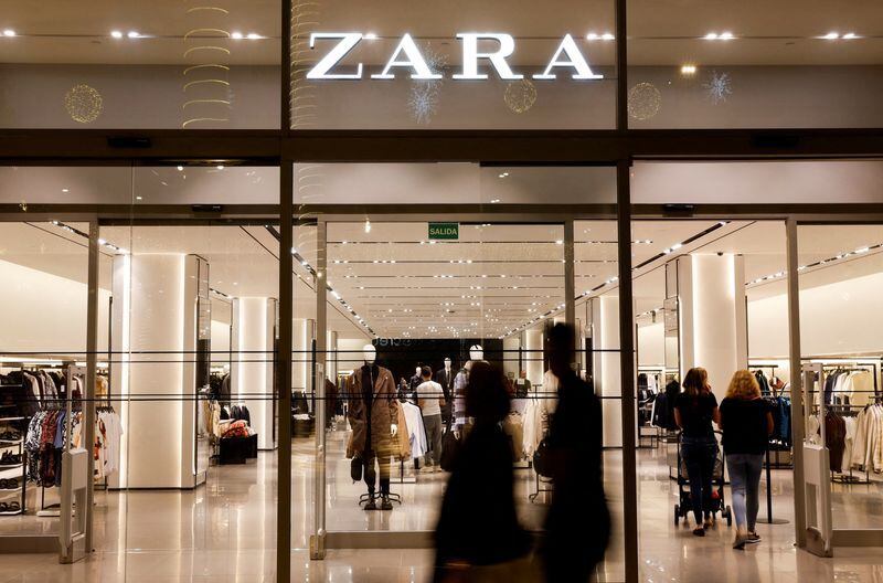 Unos compradores pasan por delante de una tienda de ropa Zara, del grupo español Inditex. (Reuters)