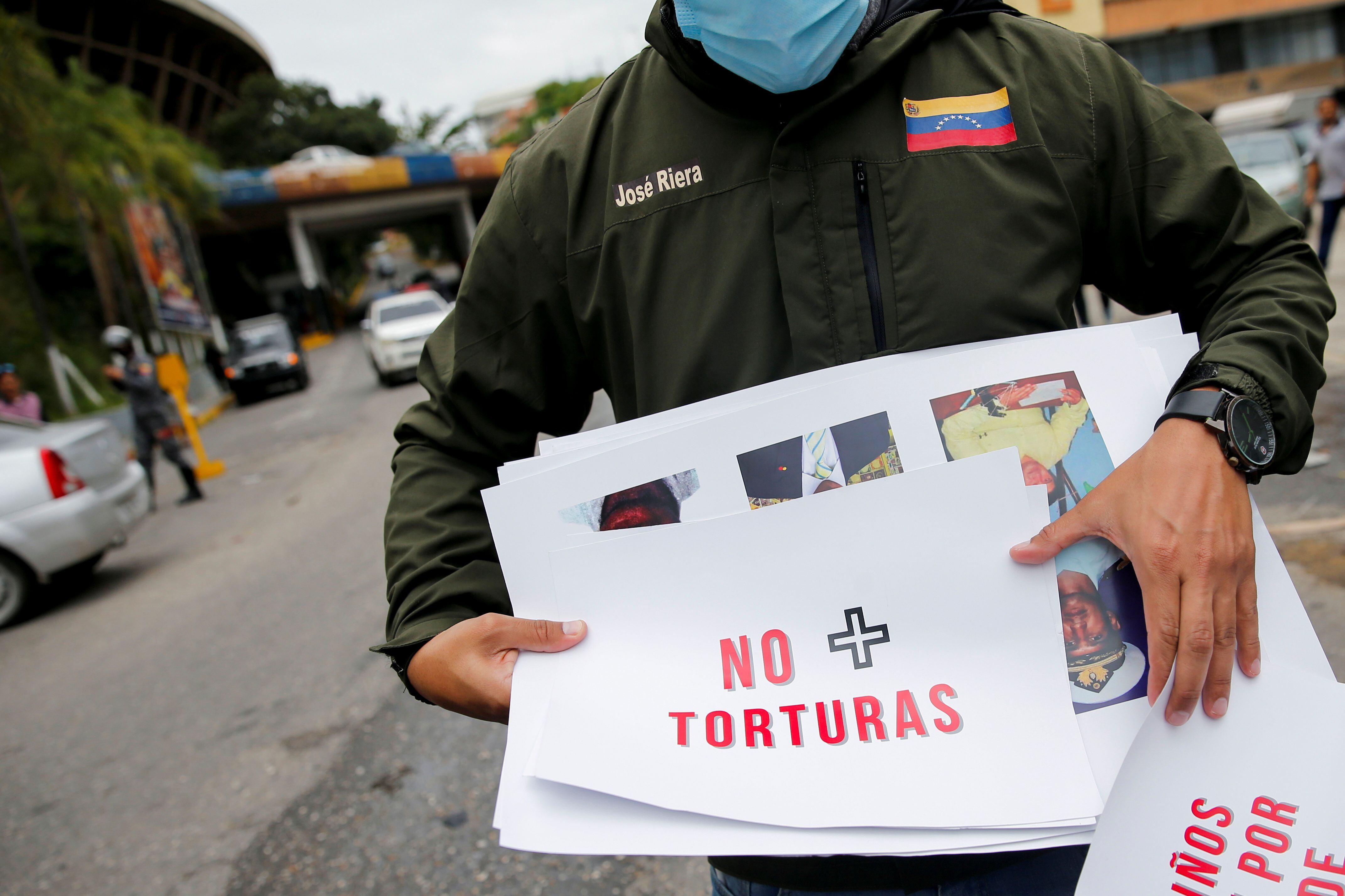 Una persona sostiene un cartel con la leyenda "No más tortura" en una protesta frente a la sede del SEBIN, en busca de la libertad de los presos políticos durante la visita del fiscal de la Corte Penal Internacional, Karim Khan, en Caracas (REUTERS/Leonardo Fernandez Viloria)