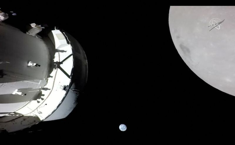 Una cámara en el ala del panel solar de Orión captura una vista de la nave espacial, la Tierra y la Luna durante el sobrevuelo de la misión Artemis I el 21 de noviembre de 2022 (NASA TV/Distribuida vía REUTERS)