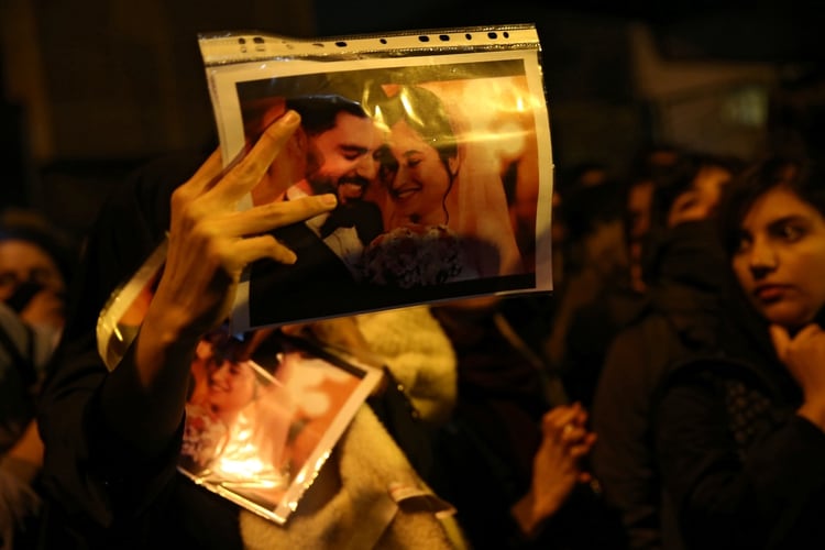 Una mujer muestra la foto de un matrimonio, víctima del derribo del avión ucraniano, durante las protestas en Teherán contra el régimen (Reuters) 