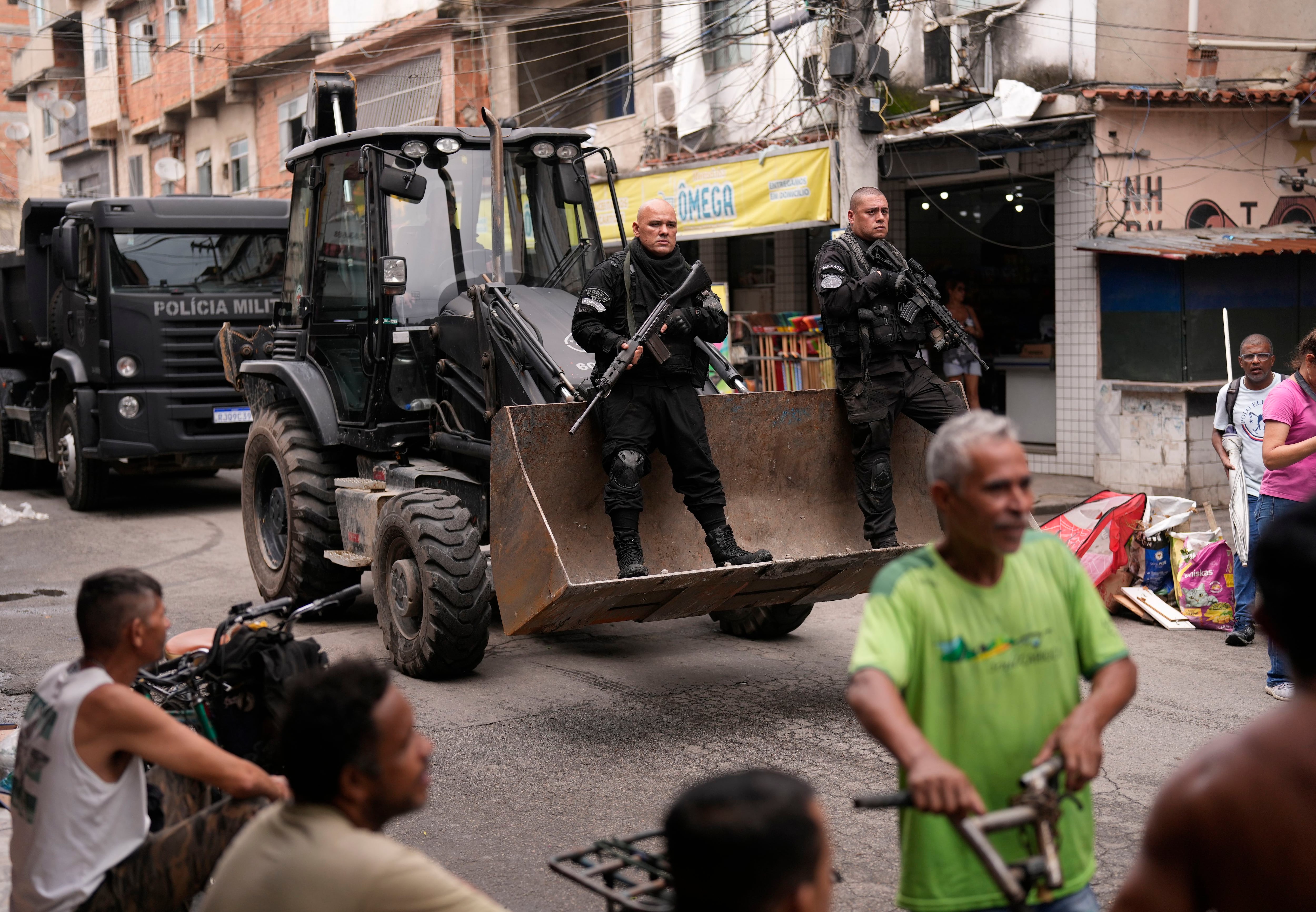 Efectivos de la policía pasan junto a residentes en Río de Janeiro, Brasil (AP Foto/Silvia Izquierdo)