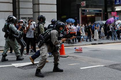 Un policía dispara contra manifestasen durante una protesta en Hong Kong (REUTERS/Tyrone Siu)