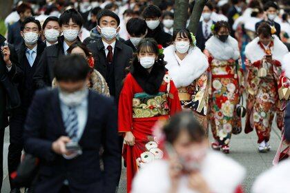 Youth including Kimono-clad women wearing protective face masks attend their Coming of Age Day celebration ceremony at Yokohama Arena after the government declared the second state of emergency for the capital and some prefectures, amid the coronavirus disease (COVID-19) outbreak, in Yokohama, Japan January 11, 2021. REUTERS/Issei Kato