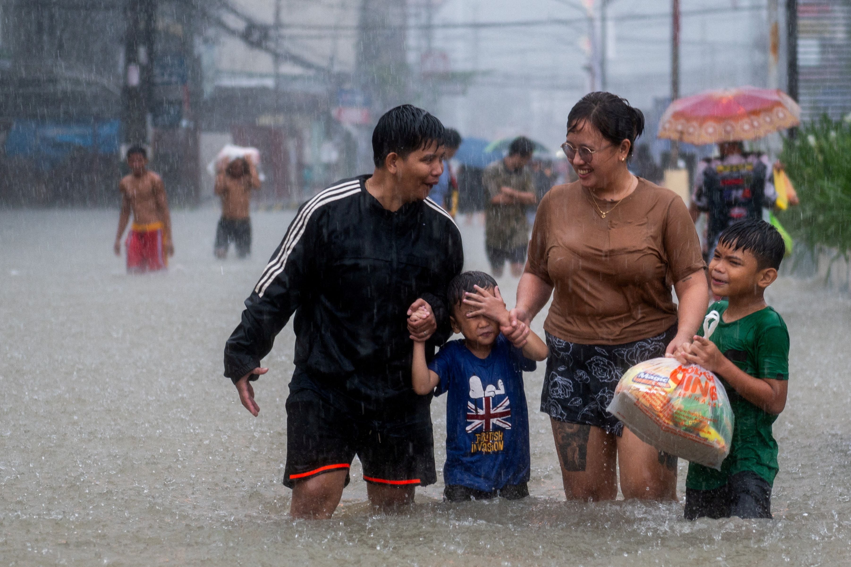 La gente camina por un camino inundado debido a las lluvias monzónicas y al reciente tifón Doksuri, en Balagtas, provincia de Bulacan, Filipinas, el 29 de julio de 2023. REUTERS/Lisa Marie David