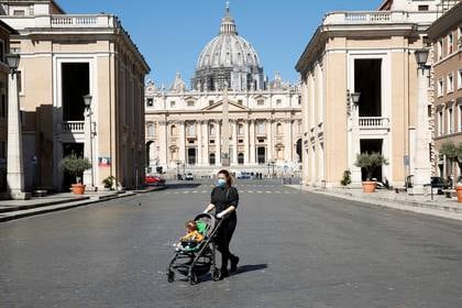 Una mujer y su bebé pasean por la Plaza San Pedro del Vaticano. Italia comienza su reapertura esta semana (Reuters)
