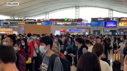 Personas en una estación de trenes en Wuhan