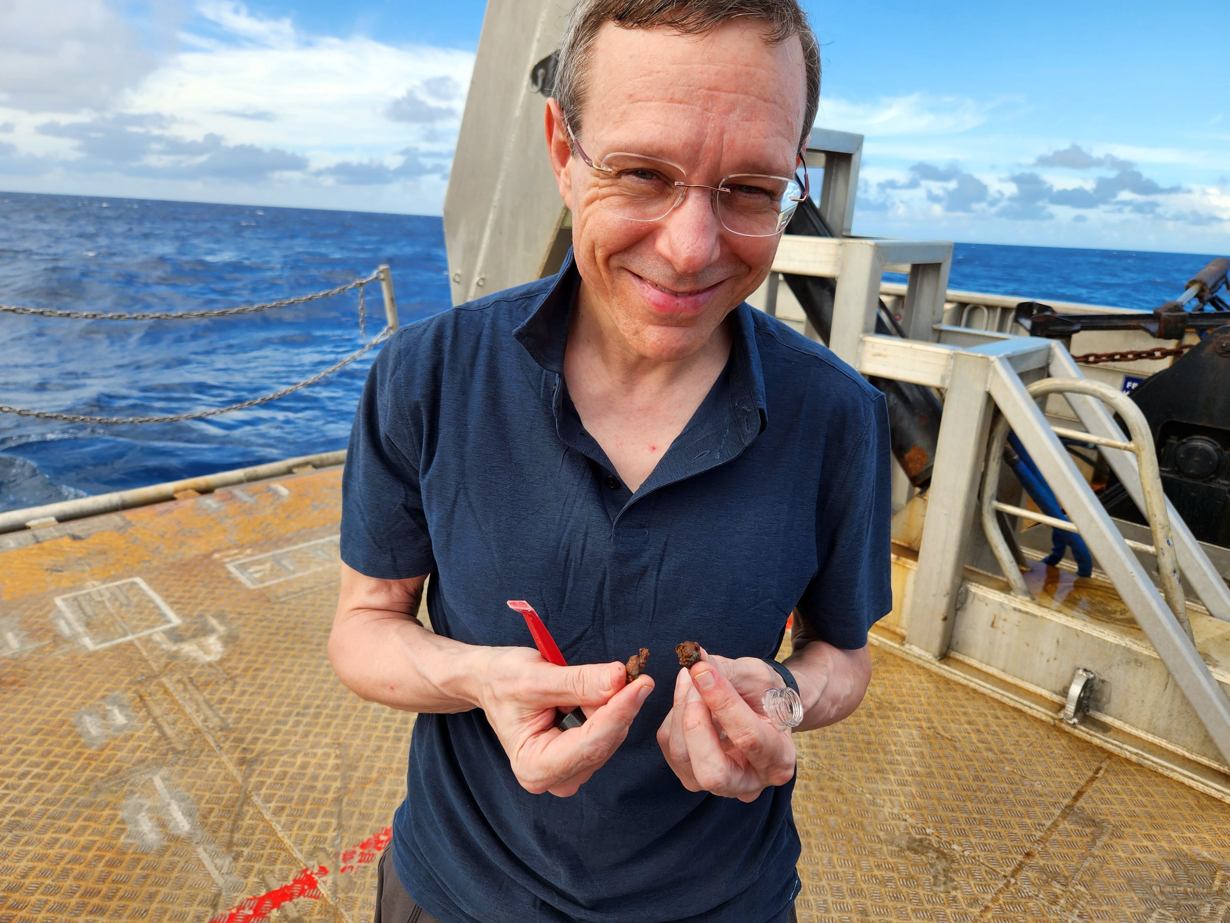 Avi Loeb con fragmentos metálicos hallados en el fondo del mar. Su trabajo despierta escepticismo entre colegas 