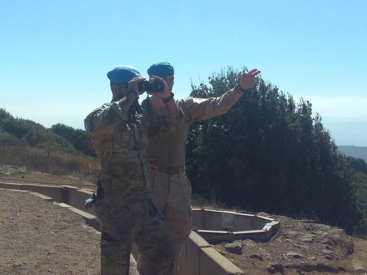 Dos soldados de la ONU observan la actividad del otro lado de la frontera entre Israel y Siria
